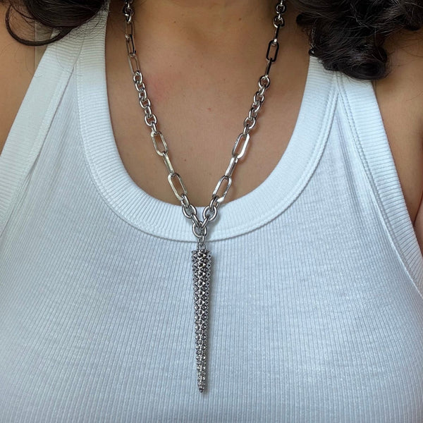 Silver chain necklace with a pendant on a white tank top