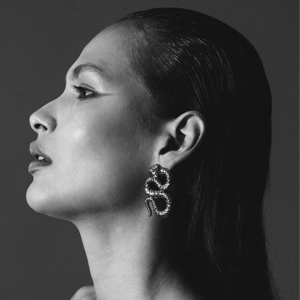 Black and white portrait of a woman wearing a unique earring.