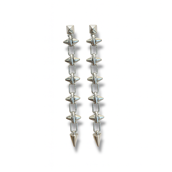 Pair of earrings with clear gemstones and silver spikes on a white background