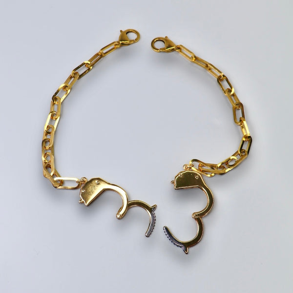 gold handcuff necklace on gray background