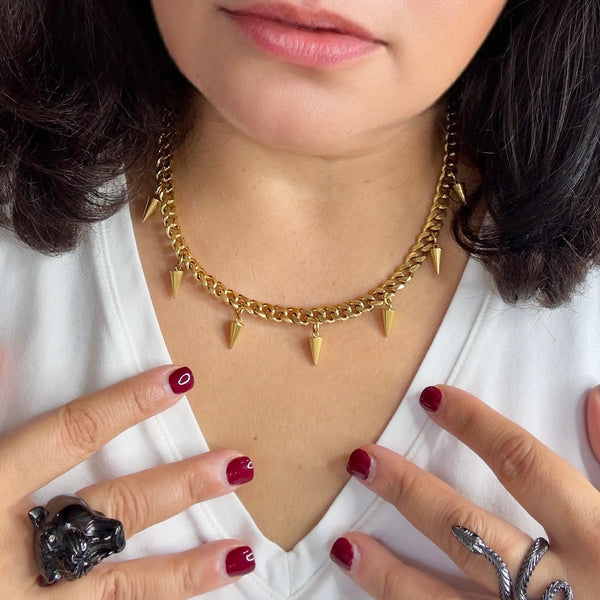woman wearing a white t shirt wearing the gold fallon necklace with 7 spikes hanging