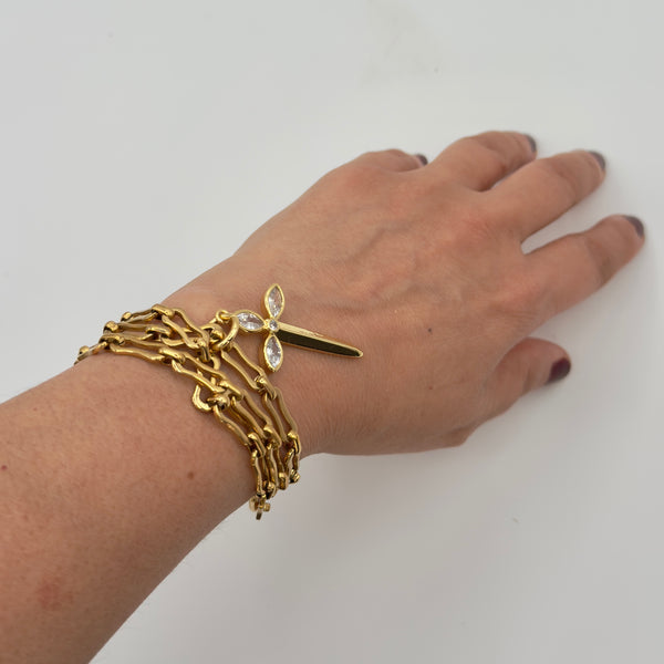 Gold bracelet with a leaf design on a wrist against a white background