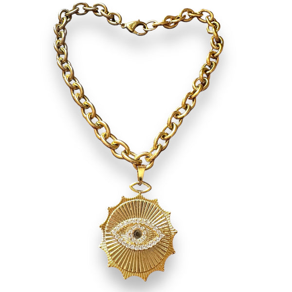 large evil eye pendant by jagged halo jewelry hanging on a chunky chain necklace in yellow gold