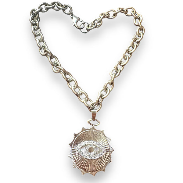 large evil eye pendant in white gold hanging on a chunky chain by jagged halo jewelry