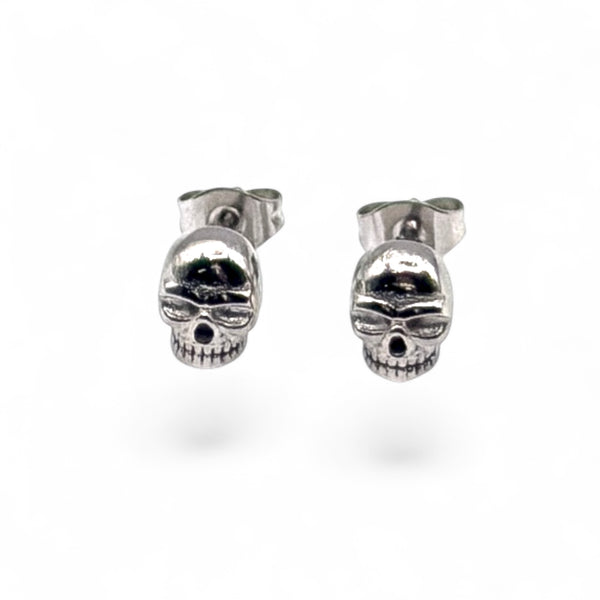 Pair of silver skull-shaped earrings on a white background