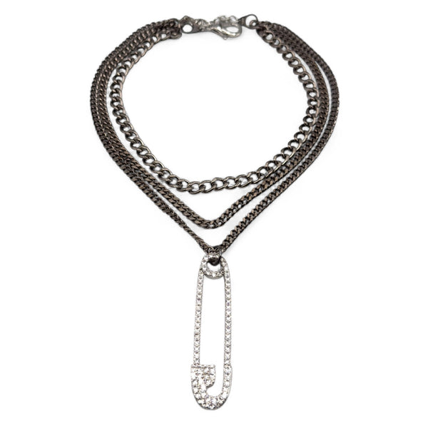 Stack of chain necklaces with a pendant on a white background