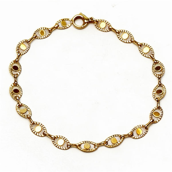 Gold bracelet with decorative links on a white background
