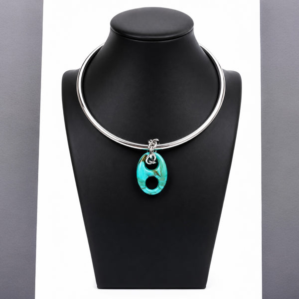Silver necklace with a turquoise pendant on a black mannequin bust.