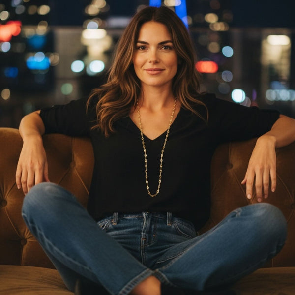 Woman sitting on a brown leather couch with a cityscape in the background