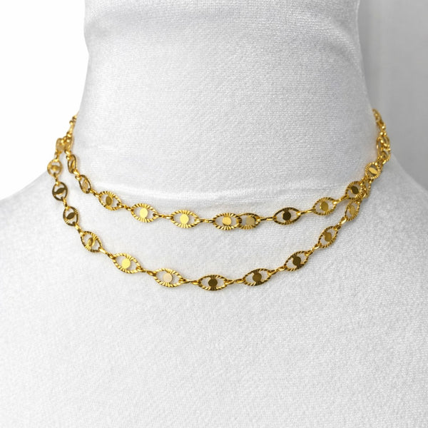 Gold chain necklace on a mannequin bust against a white background