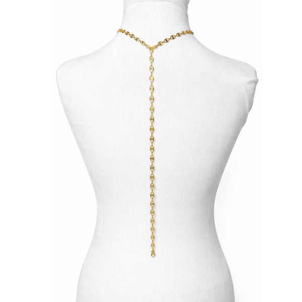 Gold chain body harness on a mannequin against a white background