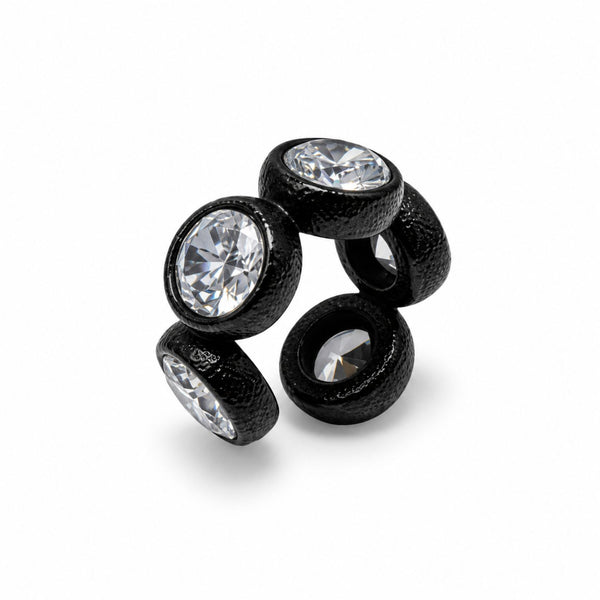 A black textured ear cuff featuring four bezel-set oval clear gemstones, photographed on a clean white background.