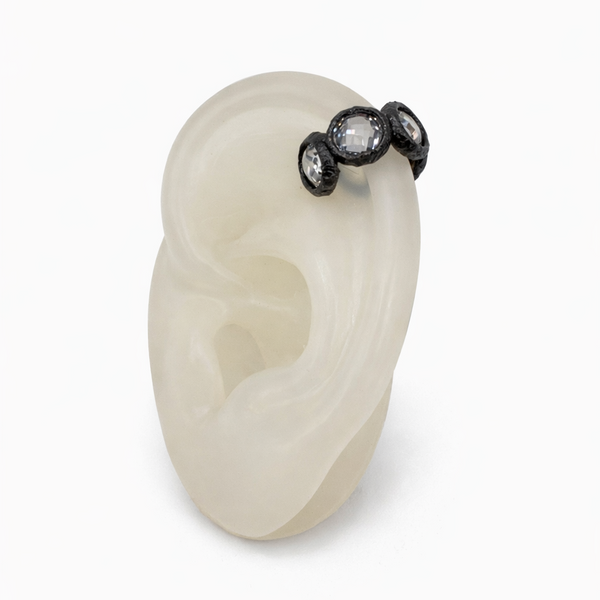 White stone earring with black gemstones on a white background