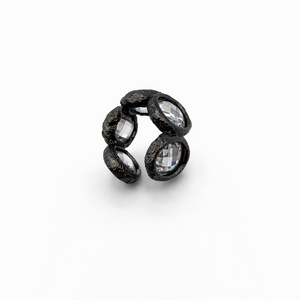 Black ring with embedded stones on a white background