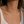 Close-up of a person wearing a silver necklace with a neutral background
