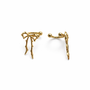 Gold bow-shaped earrings on a white background