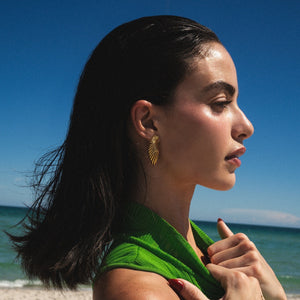 Woman with a green towel on a beach with clear blue sky