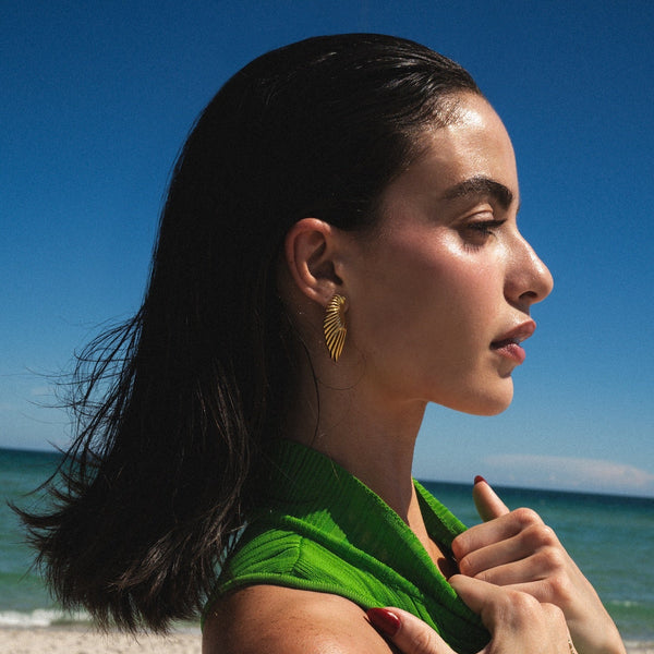 Woman with a green towel on a beach with clear blue sky