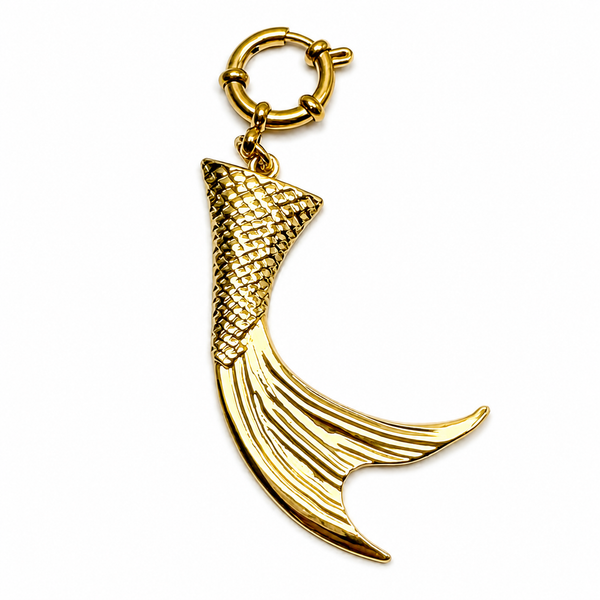 Gold mermaid tail charm on a white background
