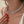 Close-up of a woman wearing a silver necklace with red nail polish on her hand.