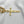 Gold bracelet with a unique pendant on a light gray background