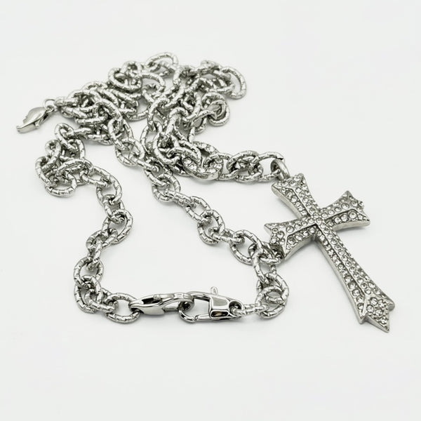Silver chain necklace with a cross pendant on a white background saints necklace by jagged halo jewelry