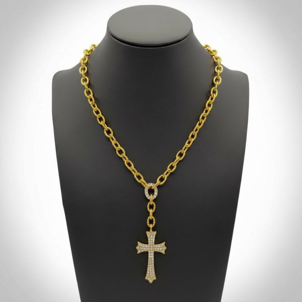 Gold chain necklace with a cross pendant on a black mannequin bust. saints cross necklace in yellow gold by jagged halo jewelry