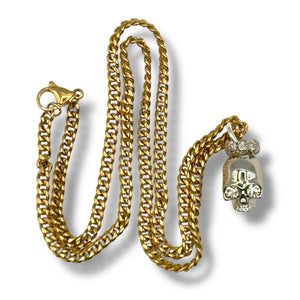 Gold chain necklace with a skull pendant on a white background