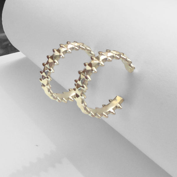 Gold hoop earrings on a white surface