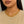 Gold chain necklace worn by a person with a neutral background