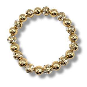 Gold beaded bracelet with clear stones on a white background