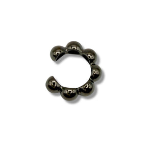 Black metal ring with spherical beads on a white background