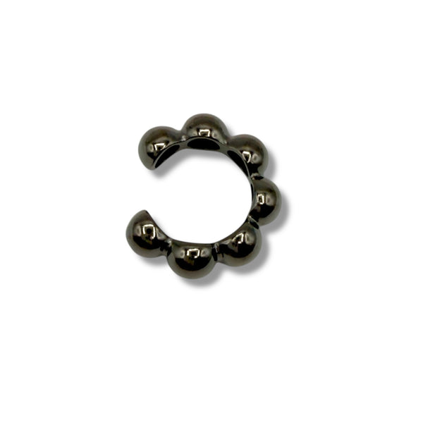 Black metal ring with spherical beads on a white background
