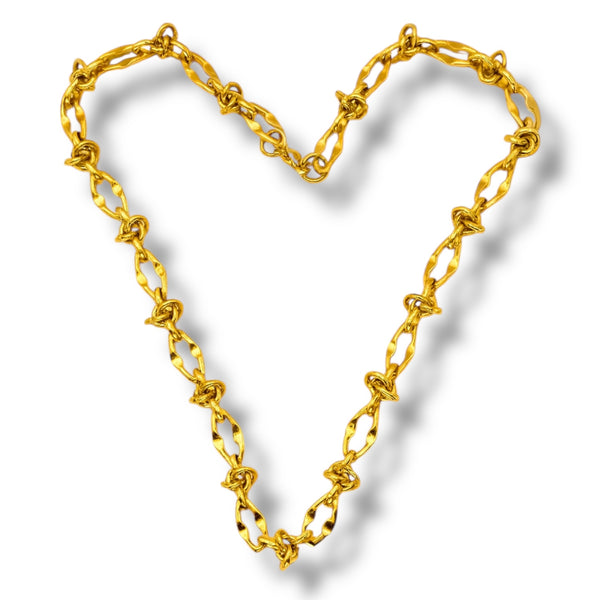 Gold chain forming a heart shape on a white background