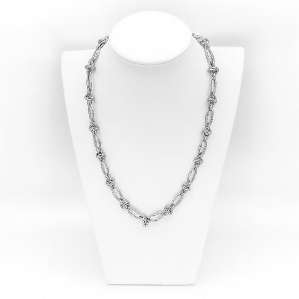Silver chain necklace on a white mannequin bust against a white background