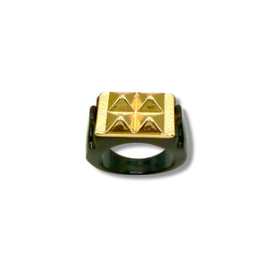 Gold and black ring with a geometric design on a white background