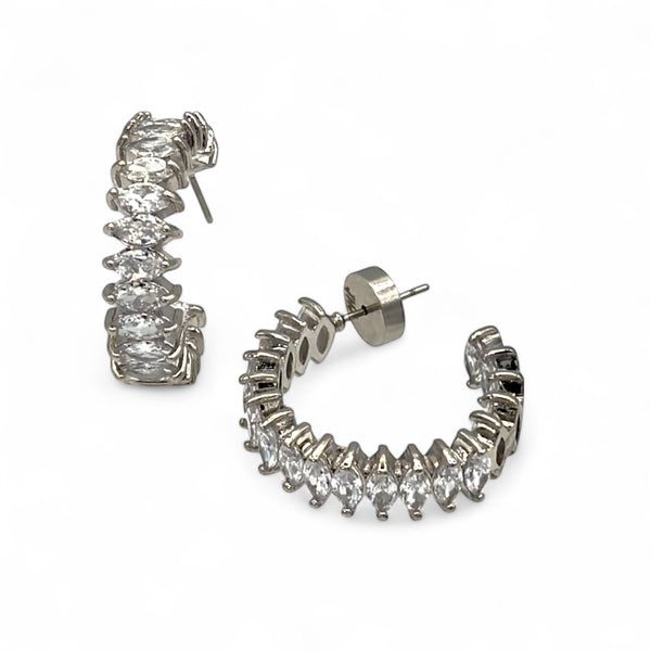 Silver hoop earrings with clear gemstones on a white background