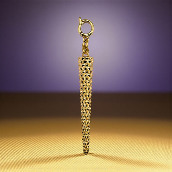Gold textured pendant on a gold surface with a purple background