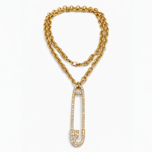 Gold chain necklace with a decorative safety pin pendant on a white background