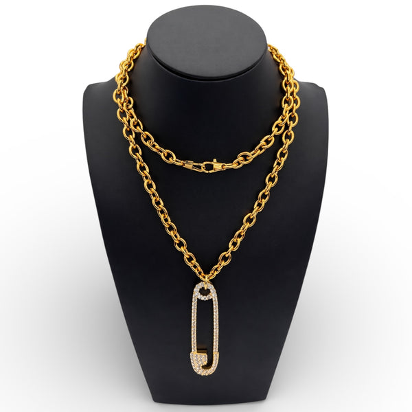 Gold chain necklace with a pendant on a black mannequin bust.