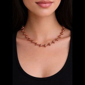 Rose gold barbie chain necklace worn by a person against a black background by jagged halo jewelry 