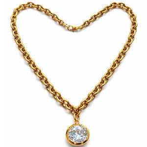 Gold chain necklace with a diamond pendant on a white background