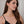 Woman wearing a gold chain necklace against a neutral background