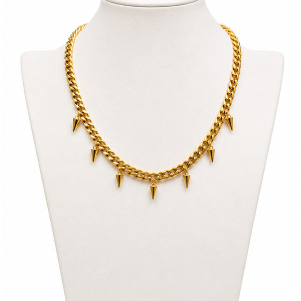 Gold chain necklace with spike-like attachments on a mannequin bust.