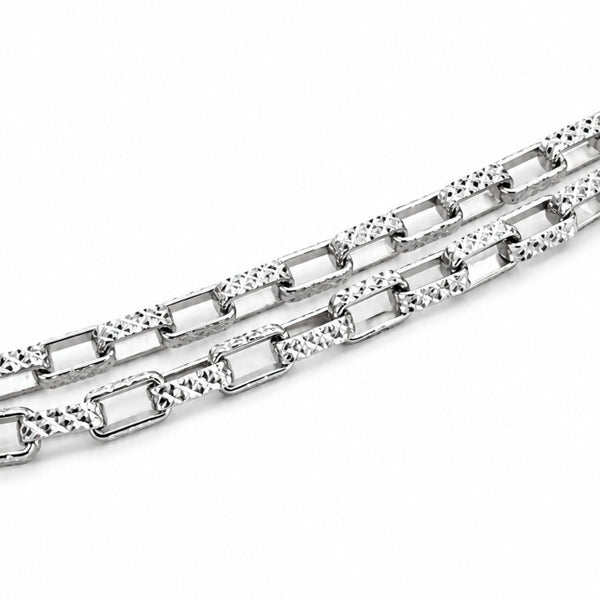 A close-up of a silver-toned metal chain with alternating rectangular links and textured oval links, photographed on a plain white background.