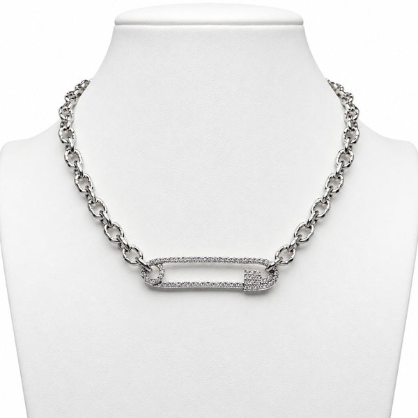 A silver-toned chain necklace displayed on a white jewelry bust, featuring a safety-pin style central bar set with small clear stones.
