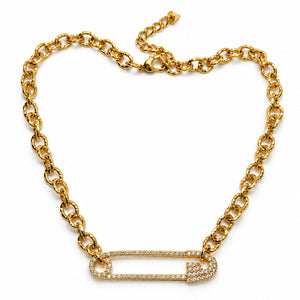 A gold chain necklace featuring a safety-pin style pendant paved with small clear stones, displayed on a clean white background.