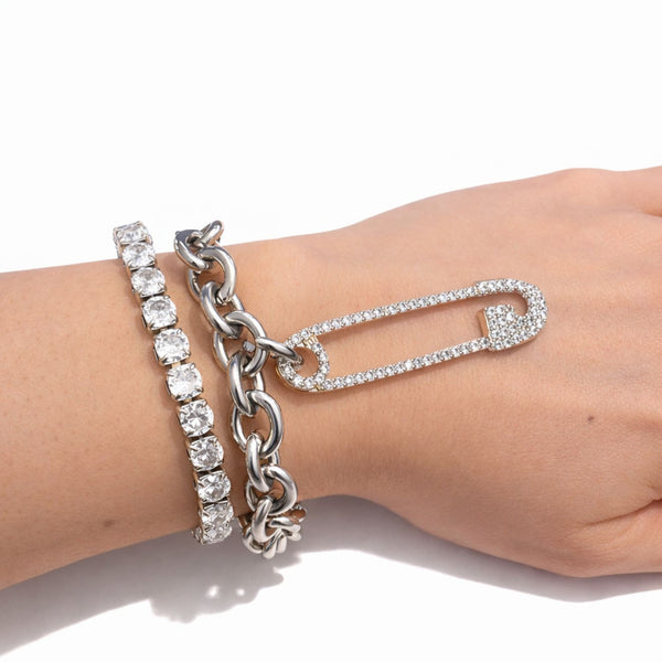 Silver bracelet with heart-shaped clasp on a wrist against a white background