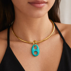 Gold necklace with a turquoise pendant worn by a person