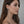 Woman wearing elegant silver earrings with a neutral background fringe tassel